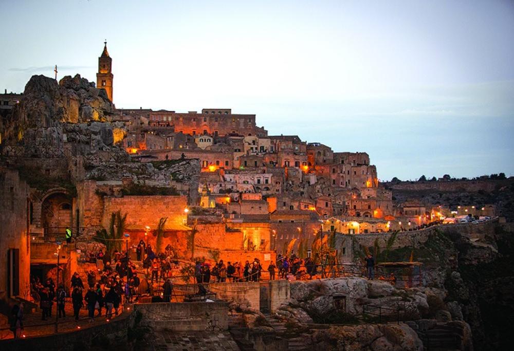 Il Sasso Caveoso al tramonto, illuminato per il Presepe Vivente, con i visitatori lungo il percorso